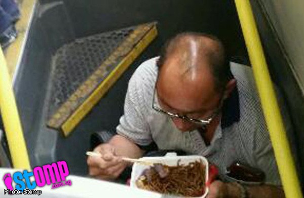 Man eats breakfast in double-decker bus stairwell