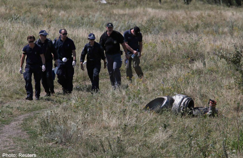 MH17: Sniffer dogs and experts comb wreckage amid fighting