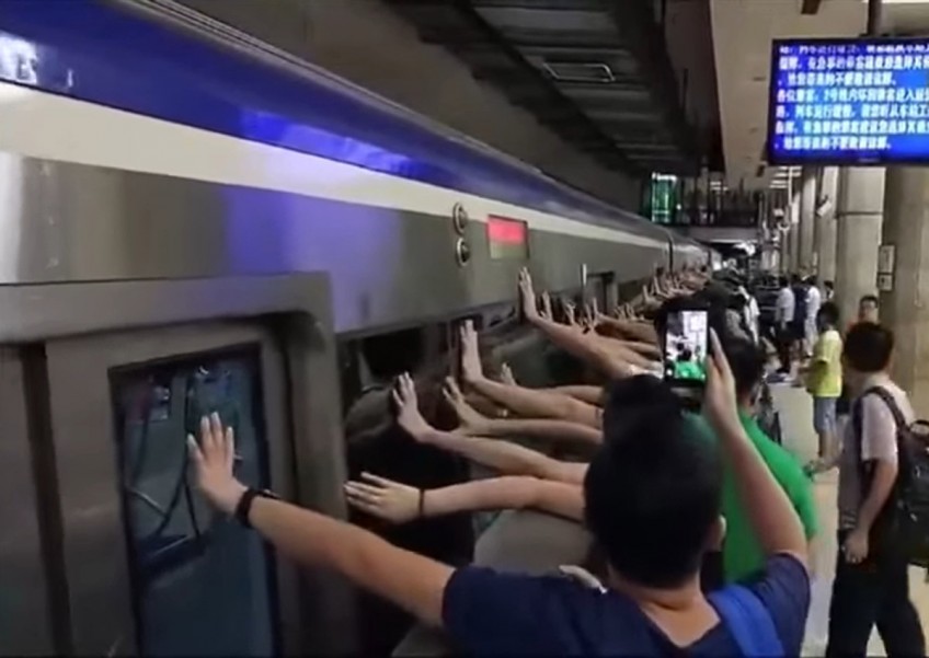 Watch how these train commuters work together to save trapped passenger