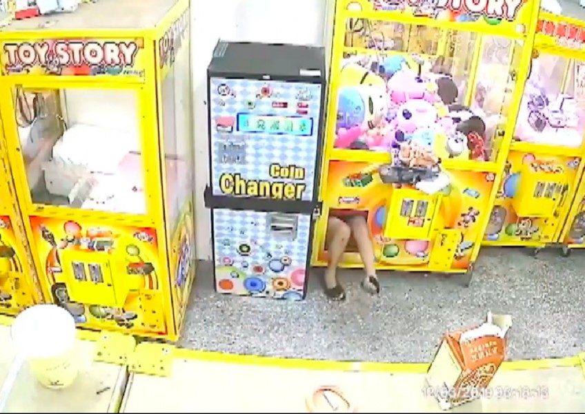Is she a contortionist? Woman in Taiwan climbs into crane machine and steals 2 plushies