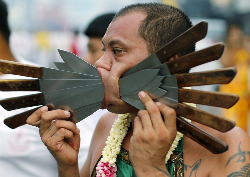 Gruesome piercing at bizarre Thai vegetarian festival