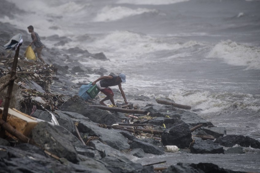 Philippines races to free 30 trapped in landslide: typhoon kills 7